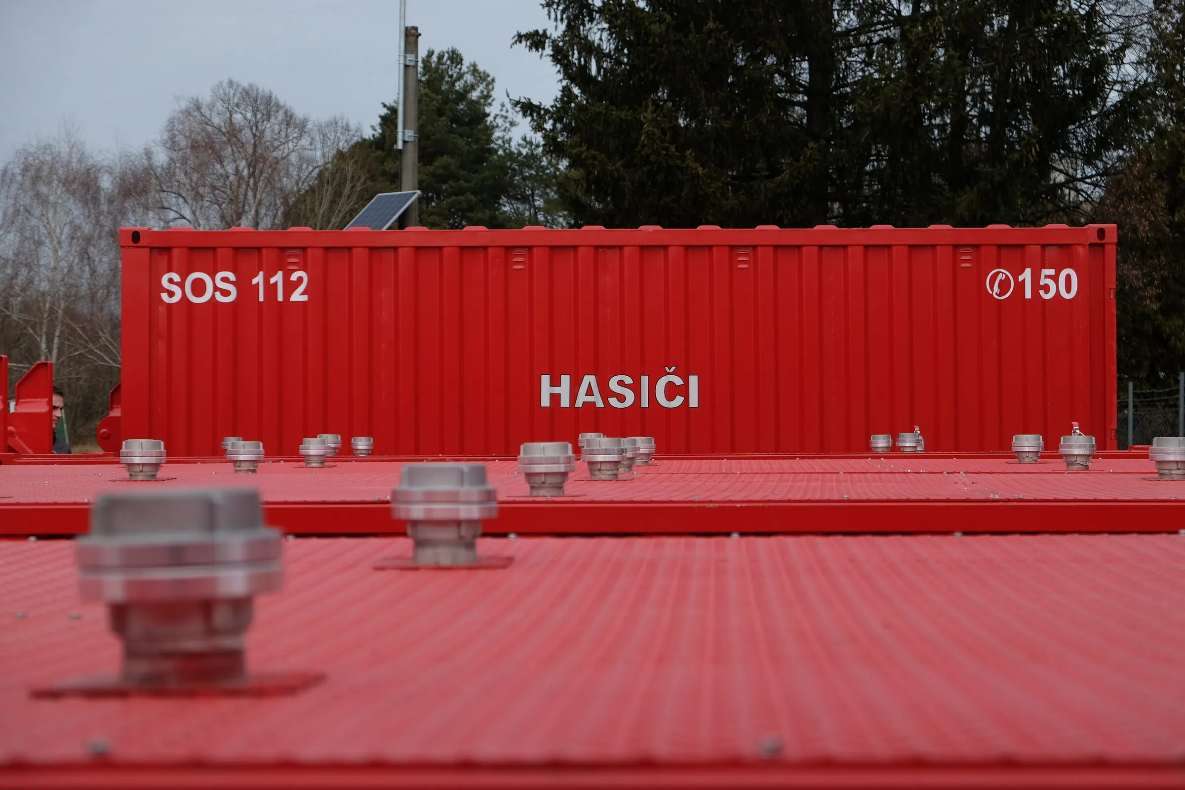 Dachkupplungen eines roten Tankmoduls mit einem 20 ft Feuerwehrcontainer dahinter