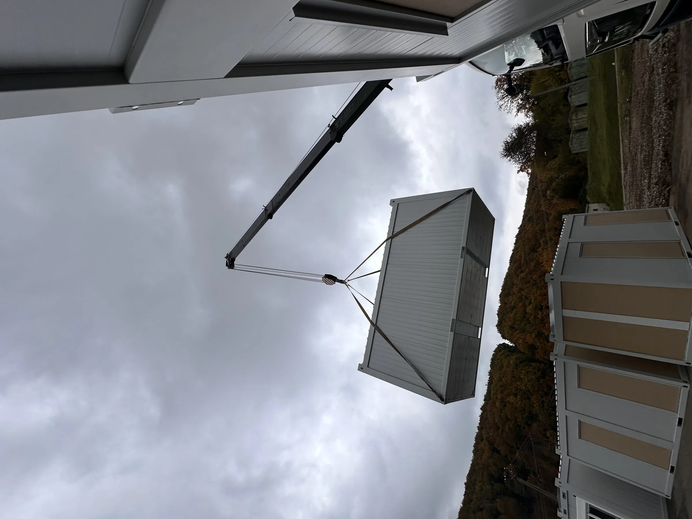Module conteneur levé par une grue sur le chantier