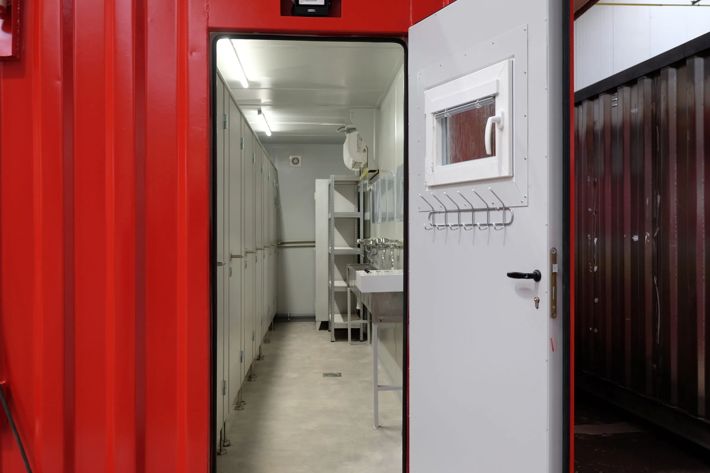 Row of sinks inside a red sanitary container