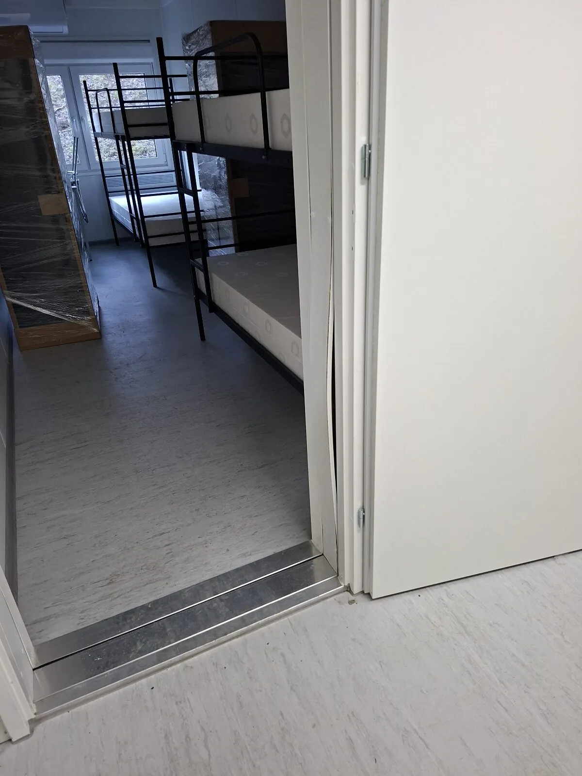 Accommodation module interior with a doorway and a bunk bed