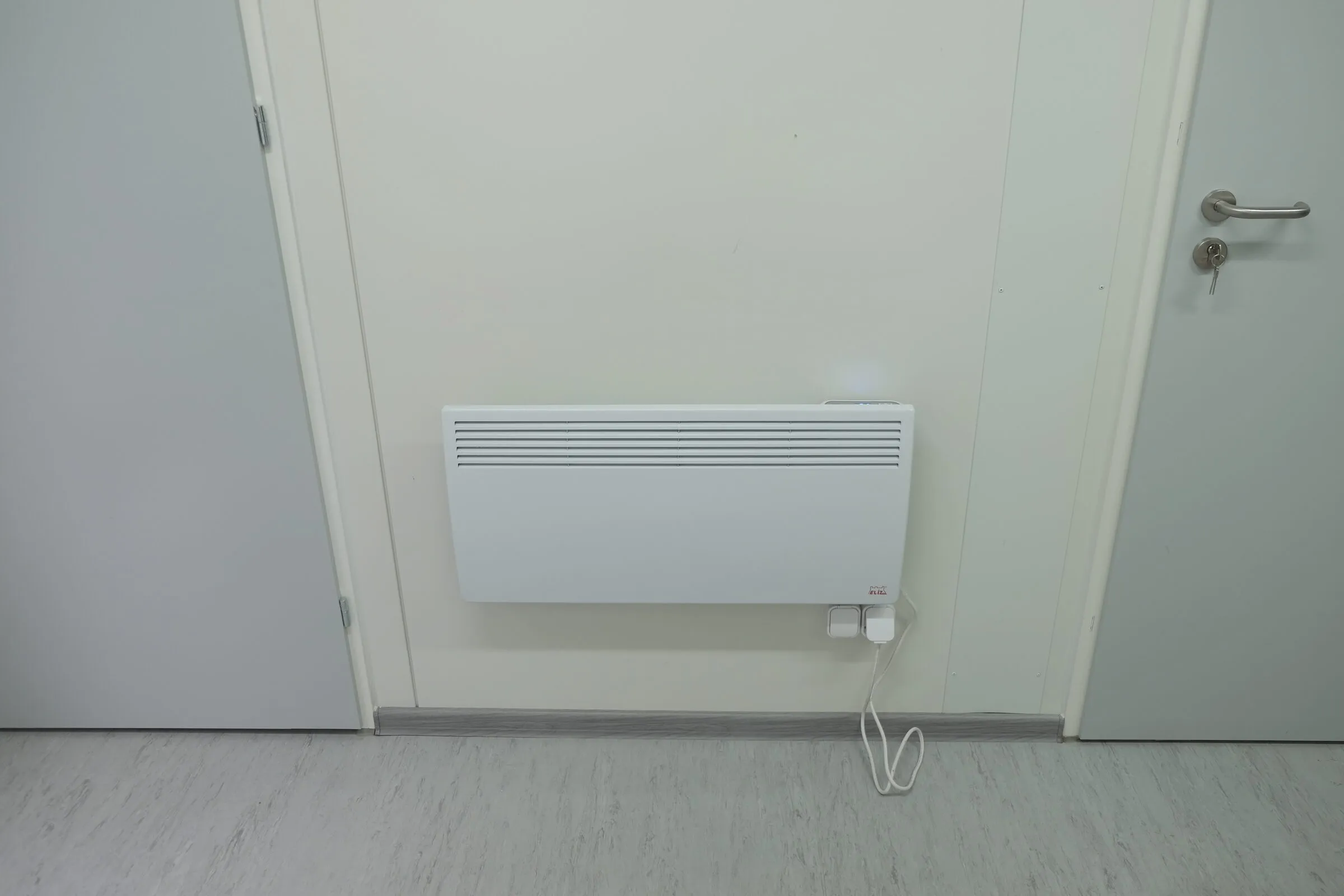 Electric wall convector beside the entry door
