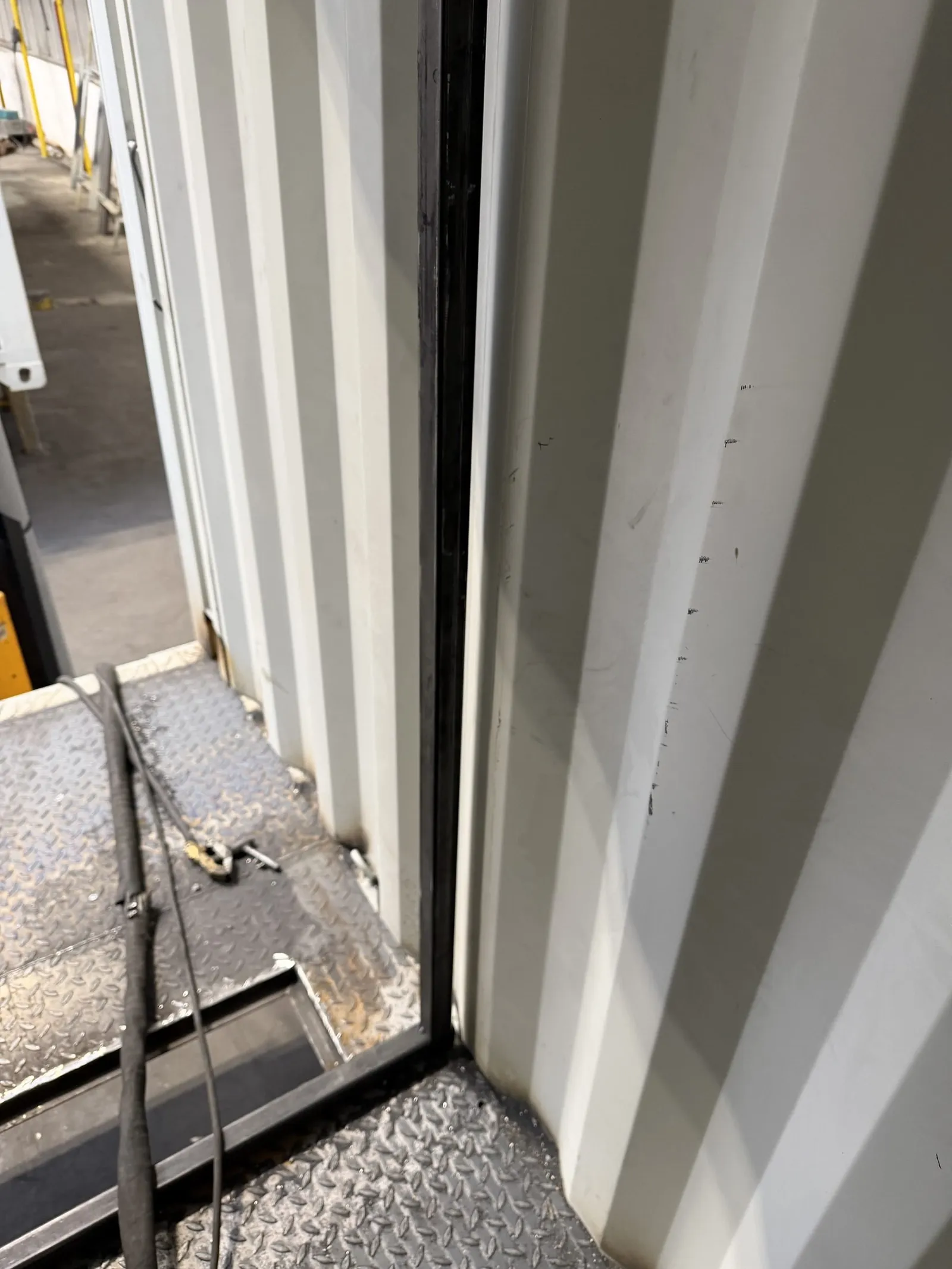 Checker-plate floor being fitted at a corner